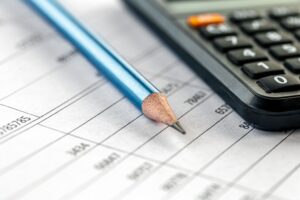 lápis, calculadora e papel para ilustrar tema do efeito do PL 3/24 sobre o processo falimentar